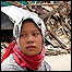 Woman in Meulaboh sitting amid damaged buildings